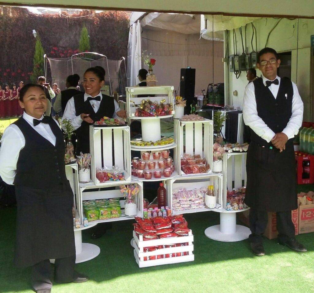 mesa de dulces con meseros para dar el servicio